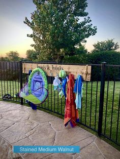 there are towels hanging on the fence by the towel rack and umbrellas in the yard