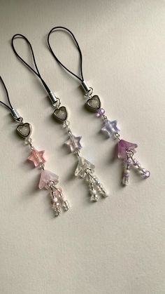 four different colored charms hanging from black cord