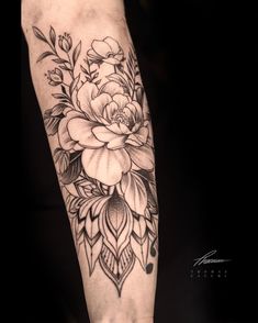 a black and white flower tattoo on the arm