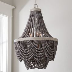 a chandelier made out of beads hanging from the ceiling in a white room