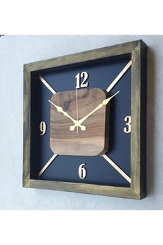 a square wooden clock with numbers on the front and sides, mounted to a wall