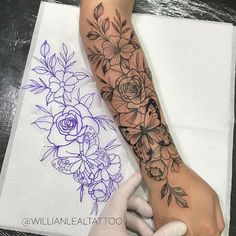 a person with a flower tattoo on their arm and hand next to a paper towel