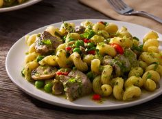 pasta with peas and mushrooms on a white plate