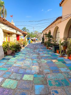 an old cobblestone street with potted plants on each side