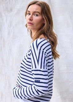 Elevate your French-girl game with this latest addition to our authentic Breton shirt collection! Tailored from our all-time best-seller shirt, MINQUIERS MODERNE, the MINQUIERS DROP features a more relaxed silouhette with dropped shoulders while maintaining the boyfriend fit and comfortable cotton we love. Made in Saint-James, Normandy, France. 100% lightweight cotton jersey. White Marine Style Long Sleeve Top, Navy Long Sleeve Marine Top, Marine Style Long Sleeve Cotton Tops, Navy Cotton Marine Style Tops, Navy Marine Style Cotton Top, Navy Long Sleeve Tops With Contrast Stripes, White Sailor Style Long Sleeve Tops, White Marine Style Cotton Tops, Navy Cotton Nautical Tops