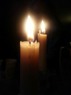 three lit candles sitting on top of a table