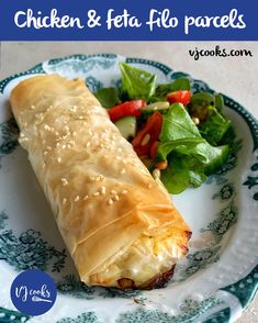 chicken and feta filo parcels on a blue and white plate next to a salad