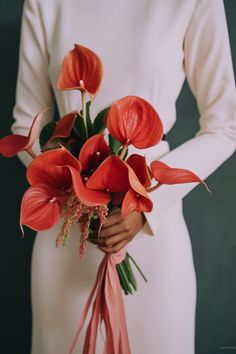 a woman holding a bouquet of red flowers