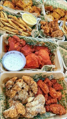 several trays filled with different types of food and dipping sauce on top of them