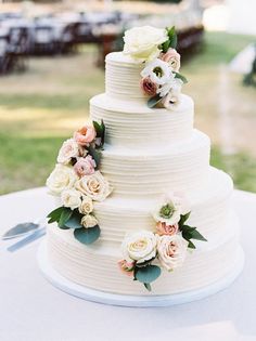 a white wedding cake with flowers on it