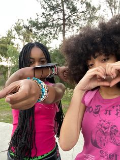 two young women standing next to each other holding scissors in their hands and looking at the camera