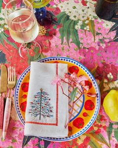 a plate with a christmas tree on it next to some wine glasses and utensils