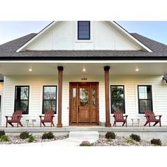 a white house with red chairs on the front porch and two doors that lead into another room