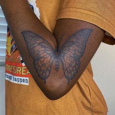 a person with a butterfly tattoo on their arm