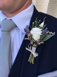 a man wearing a suit and tie with a boutonniere on his lapel