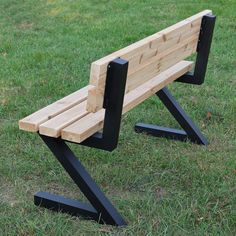 a wooden bench sitting on top of a lush green field