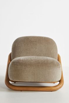 an upholstered chair with wooden legs and seat cushion in beige fabric, on a white background