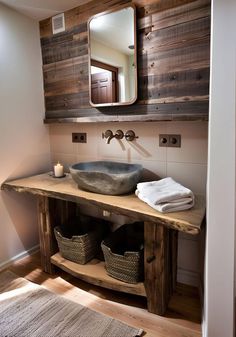 a bathroom sink sitting under a mirror next to a wooden counter