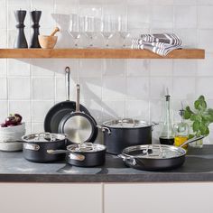 pots and pans are lined up on the kitchen counter