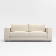 a white couch sitting on top of a white floor