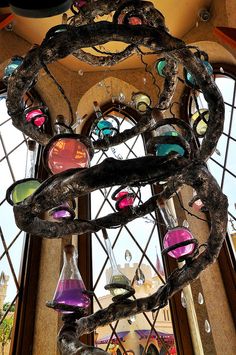 a chandelier made out of tree branches with colorful glass balls hanging from it