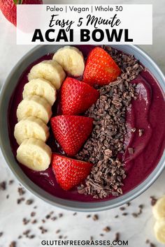 a bowl of smoothie with strawberries, chocolate and banana slices on the side