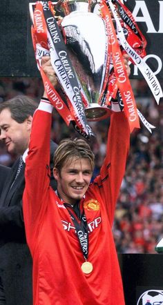 a man holding up a trophy in front of a crowd