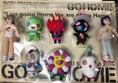 five different colored stuffed animals are in the package with tags on them, and one is wearing a t - shirt that says go home