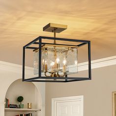 a chandelier hanging from the ceiling in a living room with bookshelves