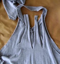 a top that is laying on a bed with the back cut out to show it's seams