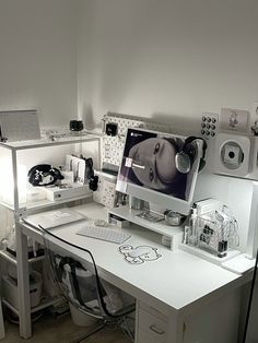 a white desk topped with a computer monitor and keyboard