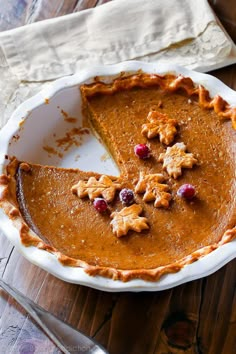 a slice of pumpkin pie on a plate with the rest of the pie in it