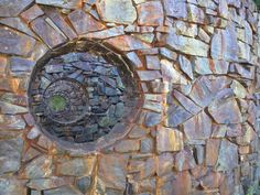 a stone wall with a circular window in it