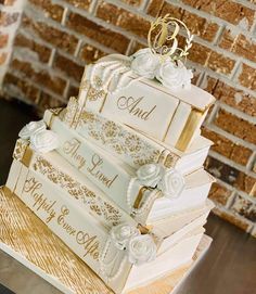 a wedding cake made to look like books with gold trimmings and white flowers