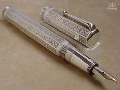 two silver pens sitting next to each other on a table