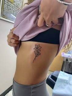 a woman with a flower tattoo on her stomach