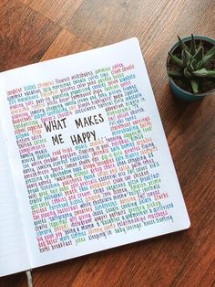 a notebook with the words what makes me happy written on it next to a potted plant