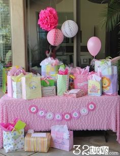 a table covered with lots of presents and balloons