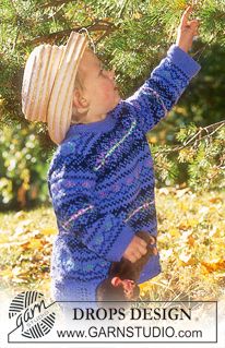 a small child reaching up to a tree with a hat on it's head