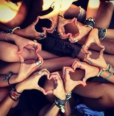 a group of women making heart shapes with their hands and rings on top of each other