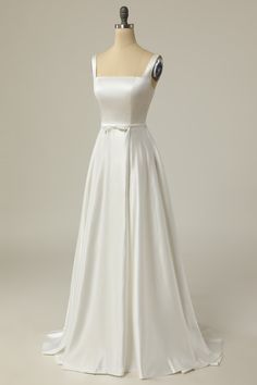 a white wedding dress on a mannequin with a large bow at the waist