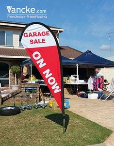 a red and white garage sale sign in front of a house