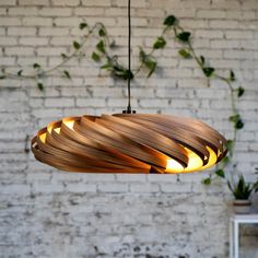 a wooden light fixture hanging from a brick wall