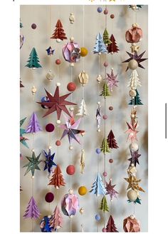 an origami christmas tree is hanging on the wall with other ornaments and decorations