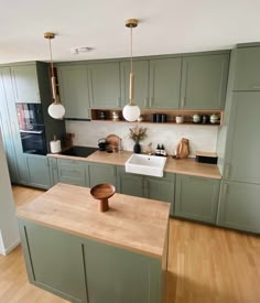 a kitchen with wooden floors and green cabinets