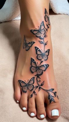 a woman's foot with butterflies on it