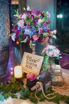 a table topped with flowers and candles next to a sign that says please higher here