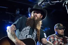 two men with long hair and beards are playing guitars