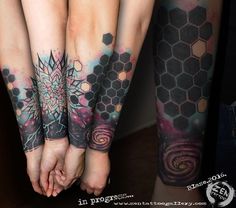 two people with tattoos on their arms and legs, both holding hands in front of each other