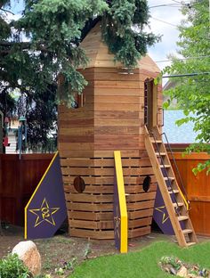 a wooden play structure with stairs and trees